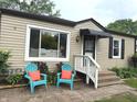 Inviting front exterior with a pair of blue chairs and bright orange pillows at 5348 Crittenden Ave, Indianapolis, IN 46220
