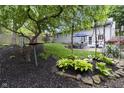 Spacious backyard with mature trees, manicured lawn, landscaped garden, and a patio with outdoor seating area at 5543 N Pennsylvania N St, Indianapolis, IN 46220