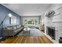 Bright living room with large window, brick fireplace, hardwood floors, and comfortable seating area at 5543 N Pennsylvania N St, Indianapolis, IN 46220