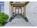 Inviting front porch with rocking chairs, potted plants, and a charming entrance at 5572 Harness Dr, Greenwood, IN 46143