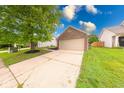 Single-Gathering home with a brick facade, attached garage, and a concrete driveway at 5633 Fox Glove Ln, Indianapolis, IN 46254