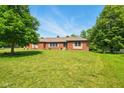 Picture of the brick home with a manicured lawn with large trees at 564 Penright Ct, Indianapolis, IN 46217