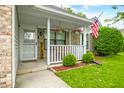 Inviting front porch with decorative hanging flowers and an American flag at 6737 Raritan Dr, Indianapolis, IN 46221