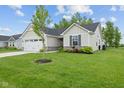 Well-maintained front yard with lush green grass and landscaping leading to a charming single-story home at 7051 E Bean Blossom Dr, Camby, IN 46113