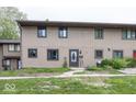 Exterior view of the townhome, featuring a well-manicured lawn and neutral-colored siding at 7940 Benjamin Dr, Lawrence, IN 46226