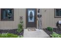 Close up of the front door with decorative glass, house number, and landscaping at 7940 Benjamin Dr, Lawrence, IN 46226