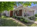 Inviting two-story home featuring a classic front porch with rocking chairs and curb appeal at 941 N Beville Ave, Indianapolis, IN 46201