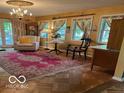 Cozy living room with classic furnishings, hardwood floors, and views to the outdoors at 9701 Hamilton Hills Ln, Fishers, IN 46038