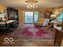 Bright living room with hardwood floors, a chandelier, and french doors leading to the outdoors at 9701 Hamilton Hills Ln, Fishers, IN 46038