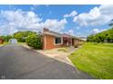 Brick home featuring a paved driveway and manicured landscaping at 105 Golf Club Rd, Anderson, IN 46011