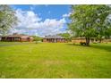 Expansive front yard view showcasing a classic brick home with mature trees at 105 Golf Club Rd, Anderson, IN 46011