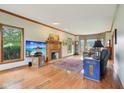 Cozy living room with hardwood floors, a brick fireplace, and large windows offering ample natural light at 1121 N Cambridge Ct, Greenfield, IN 46140