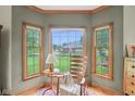 Relaxing sitting area with a rocking chair, large windows, and beautiful views of the landscaped backyard at 1121 N Cambridge Ct, Greenfield, IN 46140
