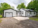 Charming white home with a well-maintained lawn and driveway leading to the garage at 1141 Temperance Ave, Indianapolis, IN 46203