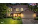 Charming two-story home with brick and siding, lush landscaping, and attached two-car garage at dusk at 11956 Glen Cove Dr, Indianapolis, IN 46236