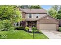 Charming two-story home with brick and siding, lush landscaping, and attached two-car garage at 11956 Glen Cove Dr, Indianapolis, IN 46236