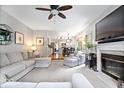Comfortable living room with fireplace, ceiling fan, and open layout with easy access to the kitchen at 11956 Glen Cove Dr, Indianapolis, IN 46236