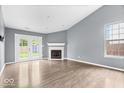 Spacious living room featuring a cozy fireplace, wood floors, and access to the backyard at 12277 E Harvest Glen Dr, Indianapolis, IN 46229