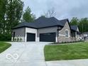 Exterior view of the property showing the attached garage, driveway and the home's architectural style at 12511 Lowery Way, Fishers, IN 46037