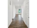 Hallway featuring hardwood floors and white walls, leading to various rooms with natural light streaming in from windows at 1354 Sambar Ct, Greenwood, IN 46143