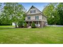 Charming two-story home with a large front yard and beautiful landscaping in a peaceful, wooded setting at 2708 N 400 E, Greenfield, IN 46140