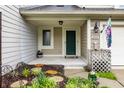 Inviting front porch entrance with dark green door and carefully manicured landscaping at 2949 River Bay N Dr, Indianapolis, IN 46240