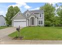 Inviting two-story home boasts a lush green lawn and a classic architectural design at 3014 Saddlehorn Dr, Carmel, IN 46033
