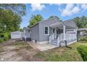 This lovely home with gray siding features an inviting outdoor space and detached garage at 3334 N Chester Ave, Indianapolis, IN 46218