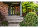 Inviting front entrance with brick steps, potted plants, and a decorative storm door at 3585 Bay Rd N Dr, Indianapolis, IN 46240
