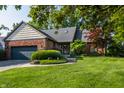 Lovely brick home with mature trees, well-manicured lawn, and attached two-car garage at 3585 Bay Rd N Dr, Indianapolis, IN 46240