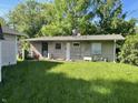 Backyard view of home with beige wood paneling and a black security door at 3908 Bertrand Rd, Indianapolis, IN 46222