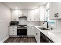 Well-lit kitchen featuring white cabinets, stainless steel appliances, and a sleek, modern design at 4926 Crittenden Ave, Indianapolis, IN 46205