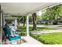 Inviting covered porch with seating and a view of the neighborhood and mature trees at 4926 Crittenden Ave, Indianapolis, IN 46205