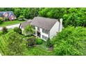 Aerial view of a beautiful house with lush green landscaping and mature trees surrounding the property at 5268 Woodfield Dr N, Carmel, IN 46033