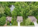 Aerial view of a home nestled among lush trees, with a pond nearby, showcasing the serene surroundings at 527 Macintosh Ln, Danville, IN 46122