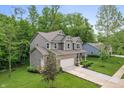 Well-maintained two-story home with gray siding, a brick accent, attached garage, and a lush green lawn at 527 Macintosh Ln, Danville, IN 46122