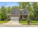 Beautiful two-story home with a brick and gray siding facade, two-car garage, and a landscaped front yard at 527 Macintosh Ln, Danville, IN 46122