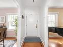 Bright foyer with hardwood floors, white trim, and arched doorways leading to other rooms at 5342 Central Ave, Indianapolis, IN 46220