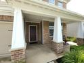 Covered front porch of a brick home featuring decorative columns and an inviting entrance at 5379 Marigold Dr, Plainfield, IN 46168