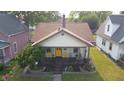 Aerial view of the charming single-story home with a welcoming front porch, garden and mature trees at 60 S 8Th Ave, Beech Grove, IN 46107