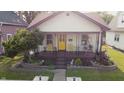 Charming single-story home with a welcoming front porch, garden, chairs and flower boxes at 60 S 8Th Ave, Beech Grove, IN 46107