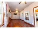 Spacious living room with hardwood floors, ceiling fan, fresh paint, natural light and ornate mirror at 60 S 8Th Ave, Beech Grove, IN 46107