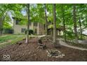 Secluded backyard with mature trees, fire pit, and seating, perfect for relaxing and entertaining at 6363 Harmonridge Ct, Indianapolis, IN 46278
