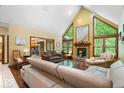 Bright living room with vaulted ceilings, fireplace, and large windows offering scenic views at 6363 Harmonridge Ct, Indianapolis, IN 46278
