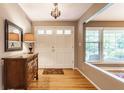 Bright foyer featuring hardwood floors, a stylish mirror, and a double door entry at 6455 N Olney St, Indianapolis, IN 46220