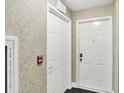 Hallway view with fire safety equipment and secure door entry to individual unit at 6518 Jade Stream Ct # 312, Indianapolis, IN 46237