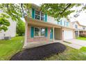This cozy two-story home features a brick accent, teal shutters, covered porch, and well-maintained landscaping at 705 Treyburn Lakes Way, Indianapolis, IN 46239
