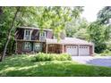 Charming brick home with a two-car garage, landscaped yard, and mature trees at 7115 Fremont Ct, Indianapolis, IN 46256