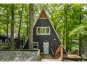A-frame home with white door, dark siding, and surrounded by lush trees at 7207 Grouper Dr, Nineveh, IN 46164