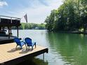 Dock view with Adirondack chairs with a peaceful lake and green trees at 7207 Grouper Dr, Nineveh, IN 46164